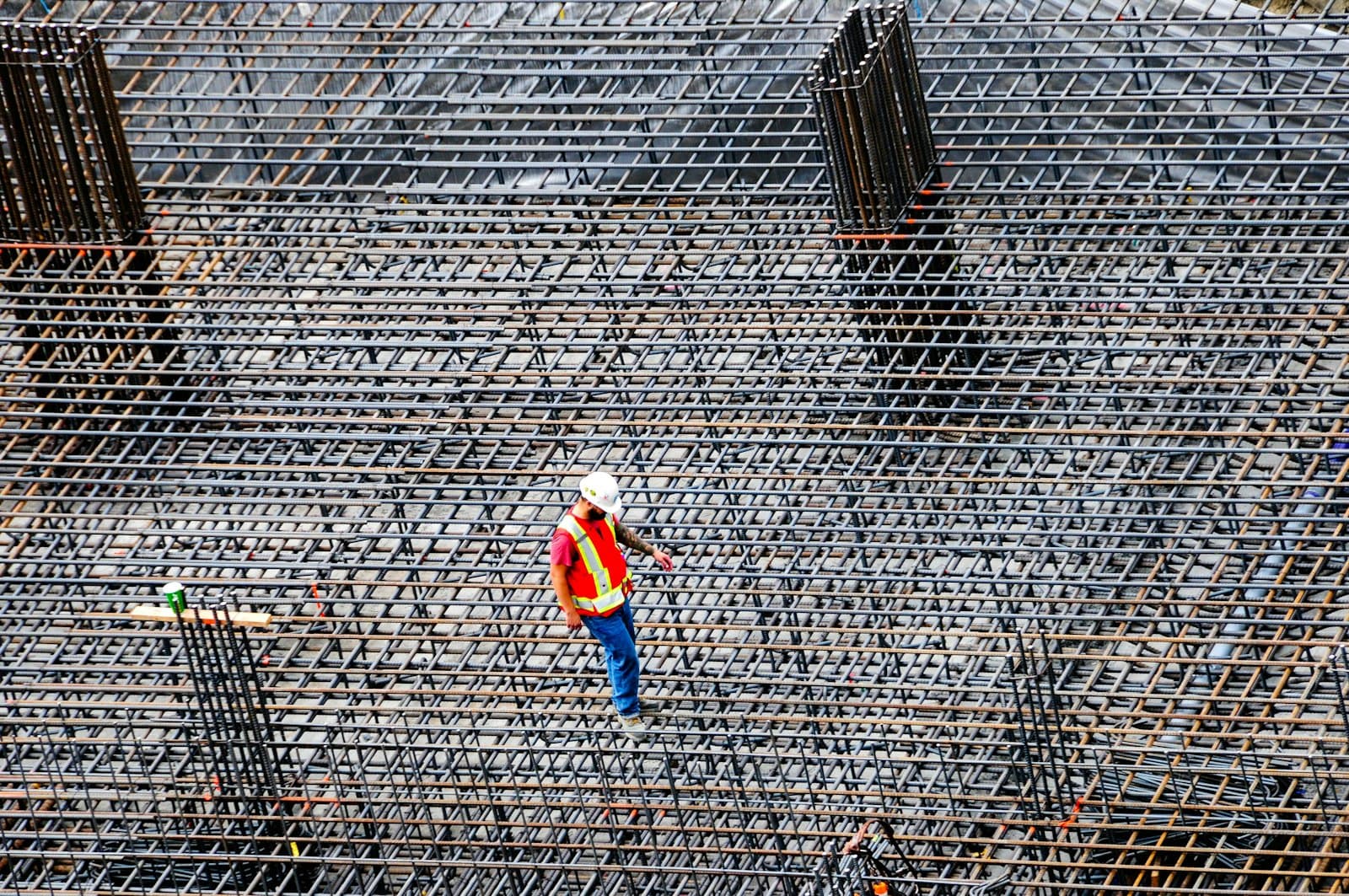 Ouvrier contrôlant le ferraillage sur un chantier