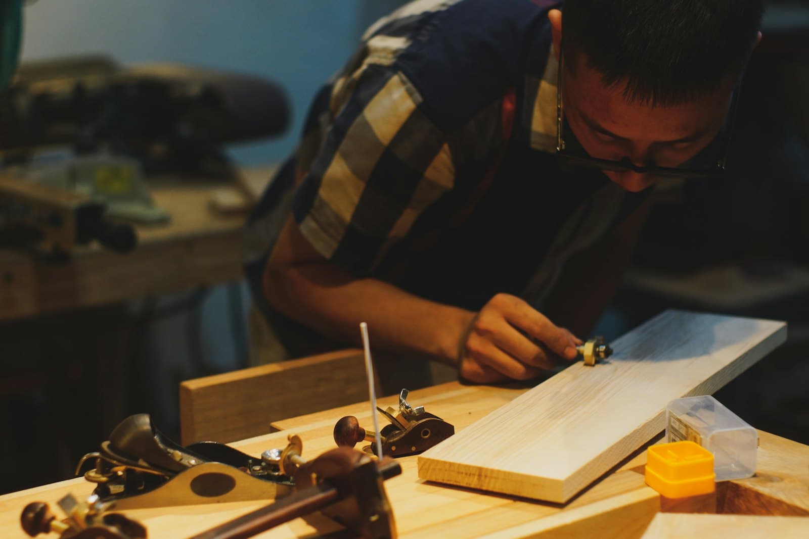 Menuisier traçant une pièce de bois dans son atelier